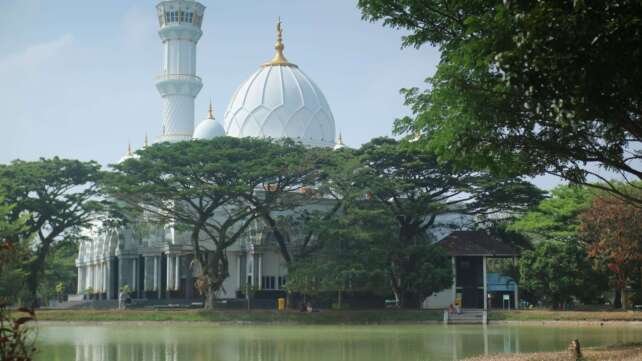 Keindahan Masjid Safinatul Ulum UIN Raden Intan berpadu telaga dan rindang pepohonan.